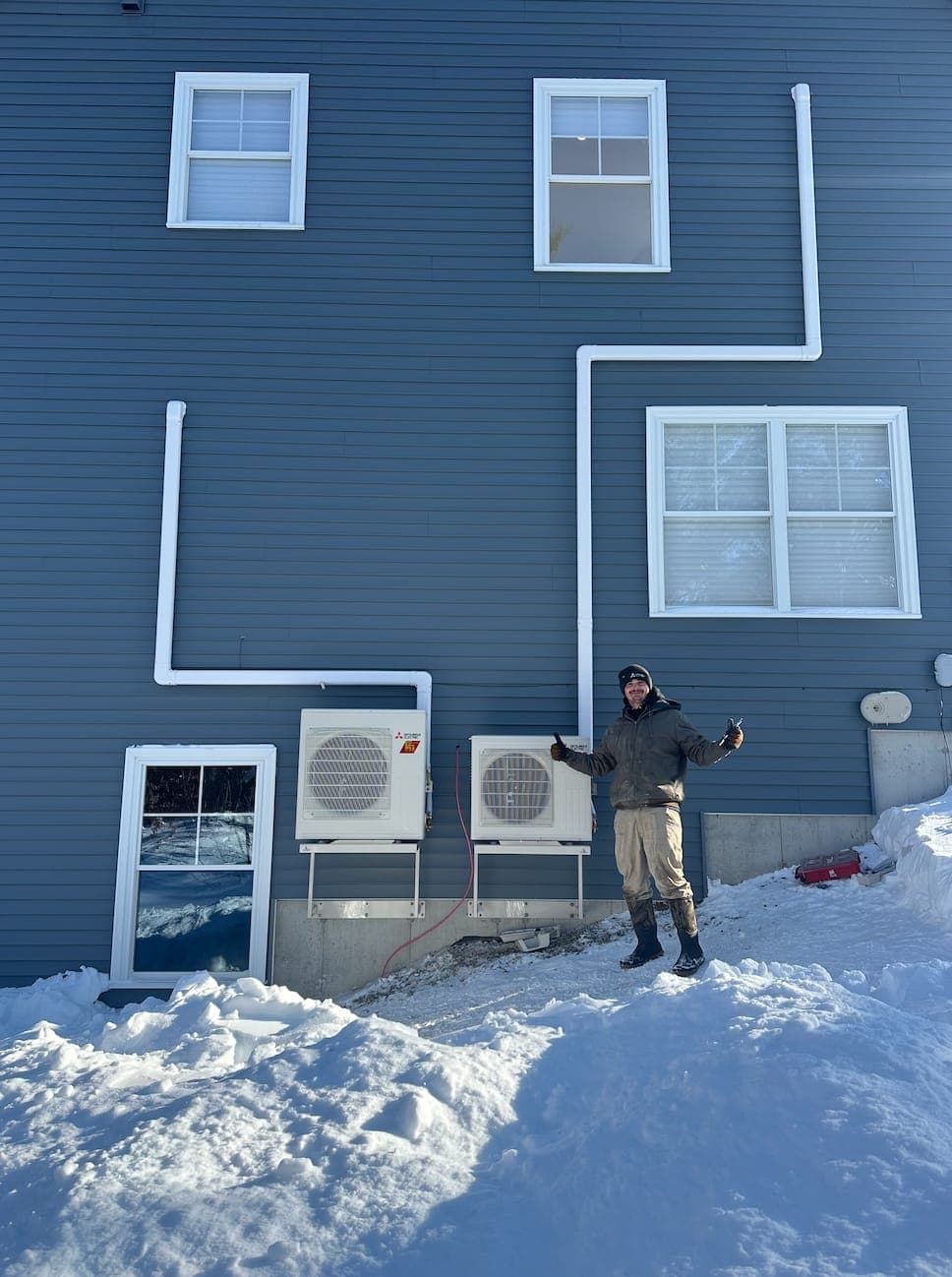 Southern Maine Heat Pumps technician completing a multi-zone heat pump install in winter