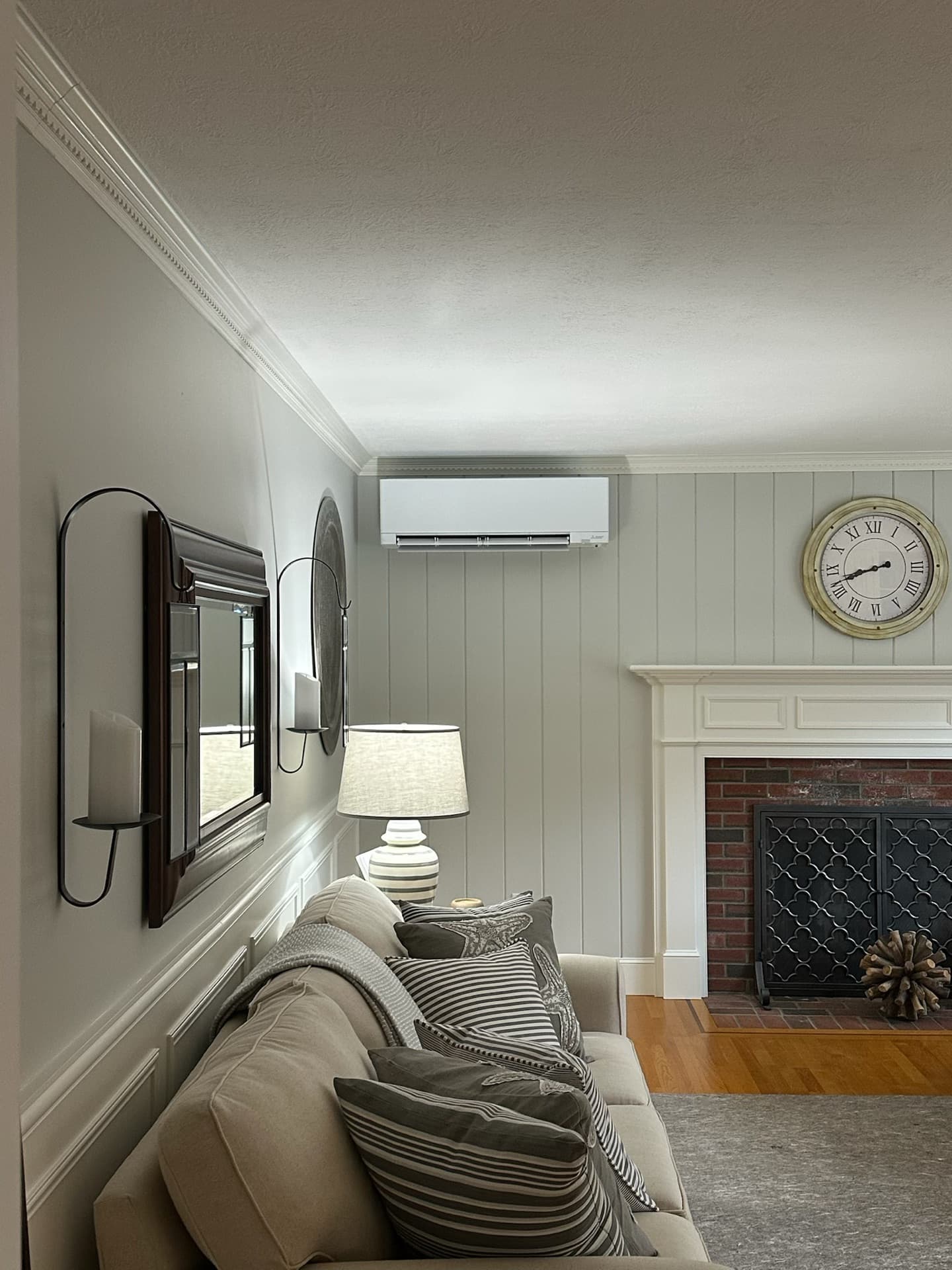 Indoor mini-split unit in a cozy living room with shiplap walls
