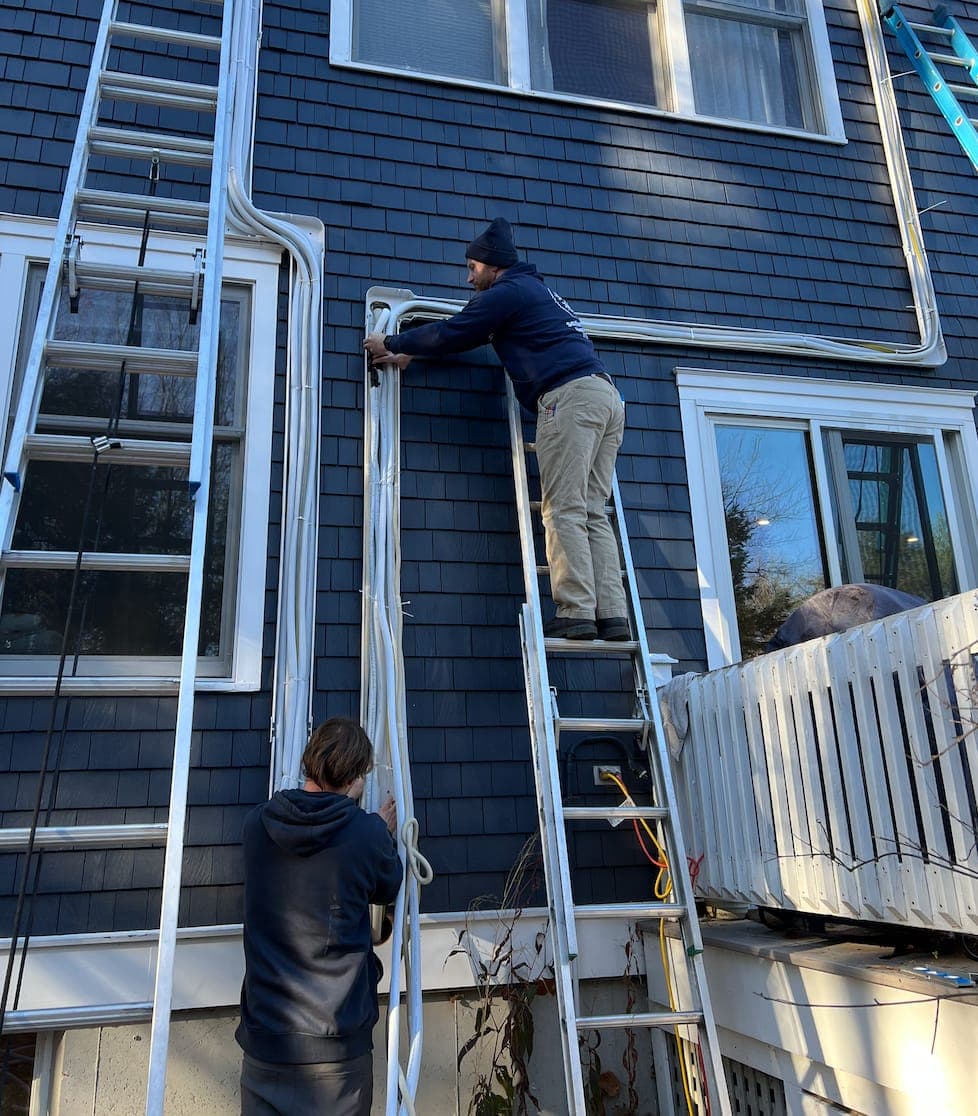 Southern Maine Heat Pumps technicians routing refrigerant line sets during installation